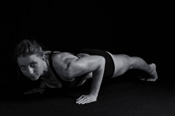 istock Fit woman with shaped muscles in push-up position in artistic conversion 1055602264