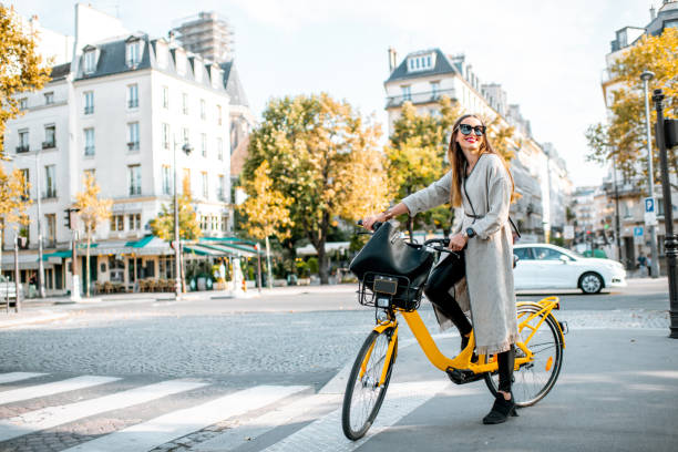 Woman with bicycle in Paris, France Portrait of a young stylish woman with yellow bicycle on the street in Paris paris fashion stock pictures, royalty-free photos & images
