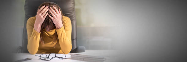 istock Desperate businesswoman with head in hands, light effect 1055608446