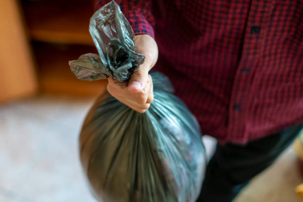 mano tenendo un sacchetto spazzatura spazzatura a casa per prenderlo via f - garbage bag garbage bag food foto e immagini stock