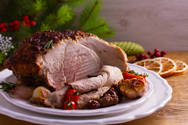 istock Baked ham with vegetables: carrots, onions, tomatoes, garlic and herbs 1055615534