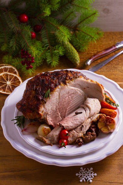 istock Baked ham with vegetables: carrots, onions, tomatoes, garlic and herbs 1055616700