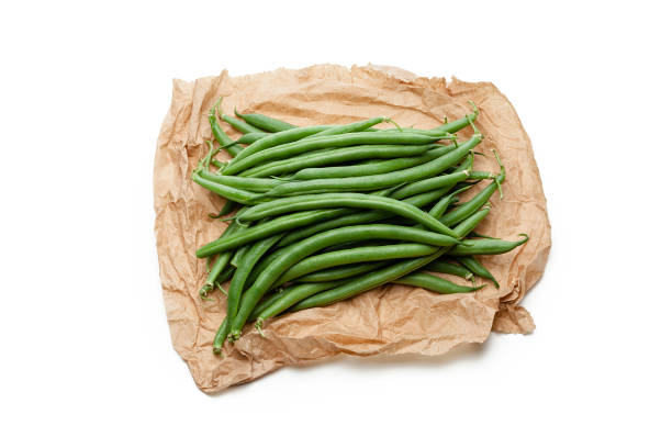 Fresh organic green beans bunch on crumpled brown paper isolated on white backdrop. Useful copy space left for text and/or logo. Predominant colors are green, brown and white. High key DSRL studio photo taken with Canon EOS 5D Mk II and Canon EF 100mm f/2.8L Macro IS USM.