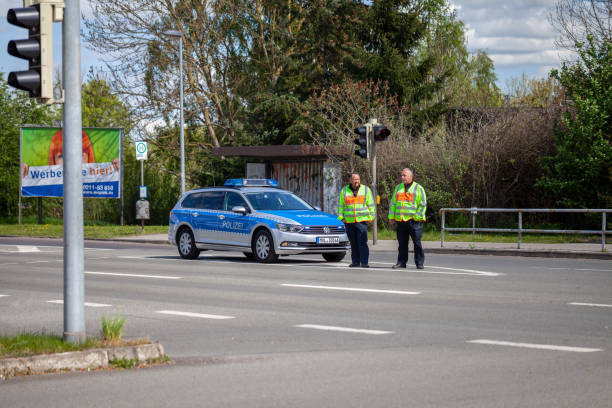 немецкая полицейская машина с двумя полицейскими стоит на улице - car prowler стоковые фото и изображения