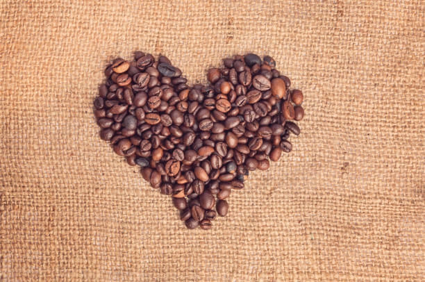 istock Drawing a heart from coffee beans on burlap. Vintage style 1055619512