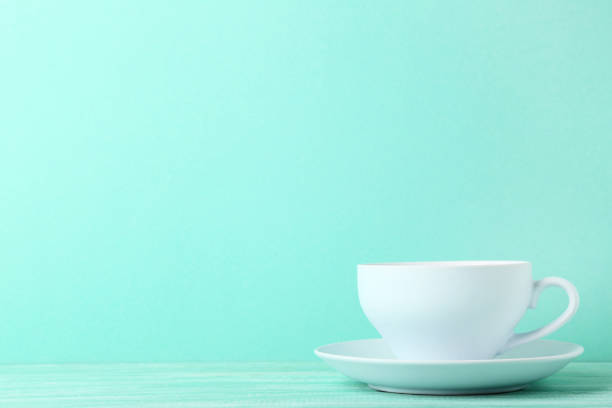 istock Cup with drink on mint wooden table 1055621090