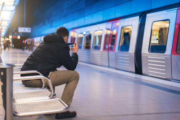 istock Man take photo  with  mobile phone in metro station. 1055642522