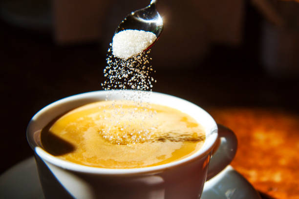 istock sugar from a spoon flies in a cup of coffee 1055643102