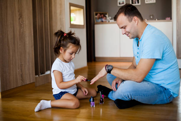 istock Father and daughter polishing nails 1055645586