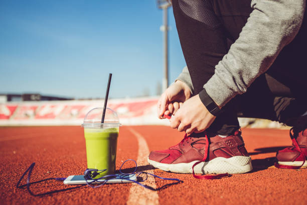 istock Woman tying shoelaces on stadium 1055655738