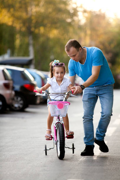 istock father teaching her daughter cycling 1055656378