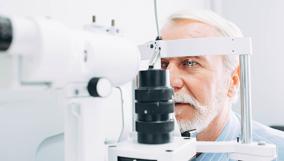Senior hombre y examen de la vista en la clínica, primer plano photo