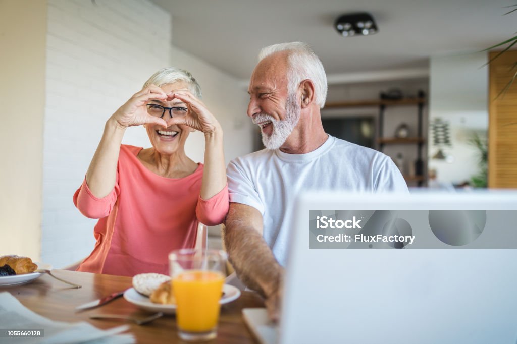 Coppia innamorata godendosi il loro tempo durante la colazione - Foto stock royalty-free di Simbolo di cuore