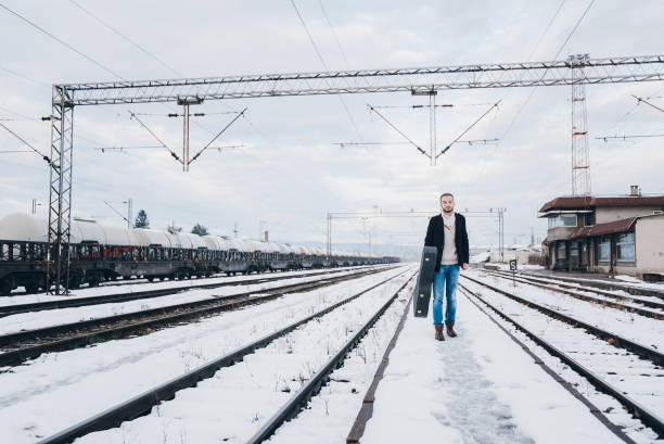 istock Musician standing on rail tracks 1055661410