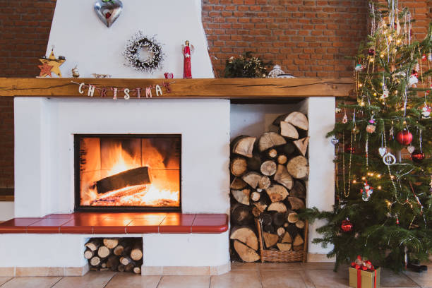 istock Christmas tree by the glowing fireplace 1055667492