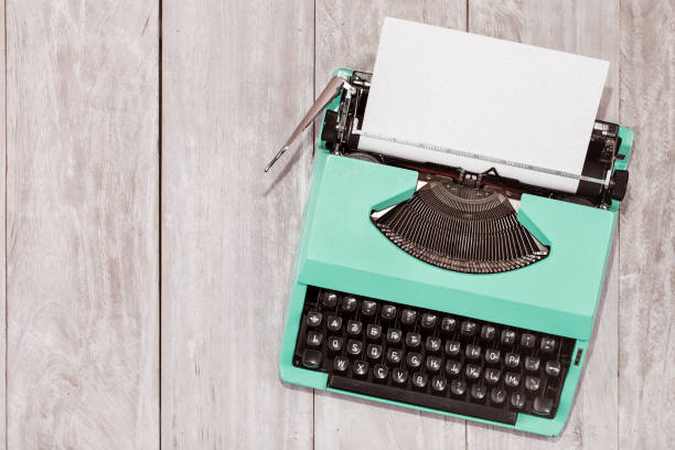 istock Retro old mint green typewriter with paper sheet on wooden table 1055670660