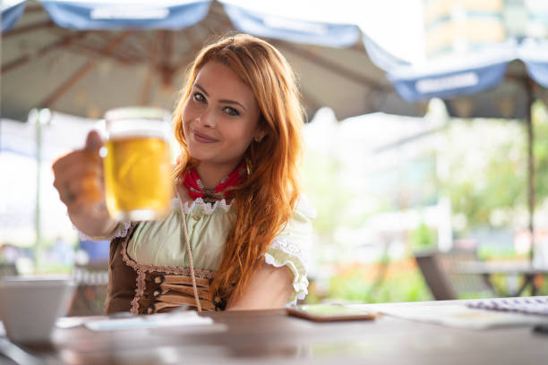 Beautiful Woman Showing Beer at Pub Party Time oktoberfest beer stock pictures, royalty-free photos & images