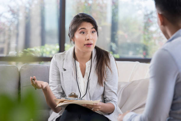istock Female counselor talks with male patient 1055689290