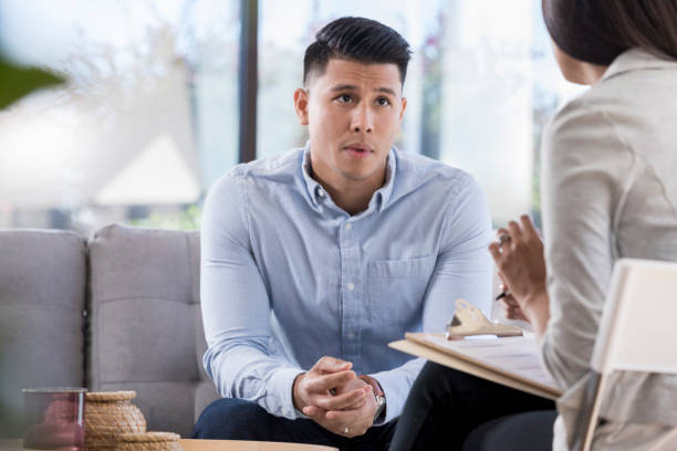 istock Depressed man talks with mental health professional 1055689294