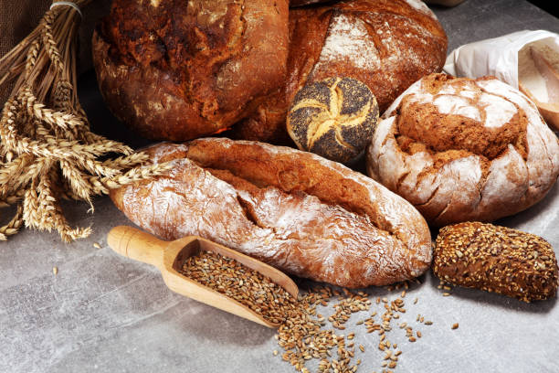 istock Different kinds of bread and bread rolls on board from above. Kitchen or bakery 1055690756