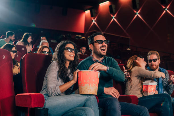 istock Smiling couple eating popcorn at 3D cinema 1055691702