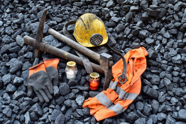istock Vigil light, candle with the miner belongings (helmet, gloves, pickaxe, vest, belt) 1055693330