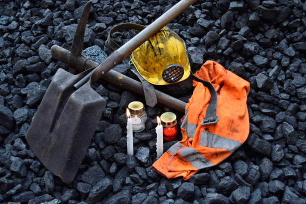 istock Vigil light, candle with the miner belongings (helmet, pickaxe, shovel, vest, belt) 1055693650