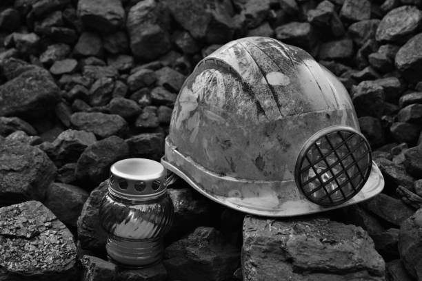 istock Vigil light, candle with mining helmet on cheap of coal 1055693840