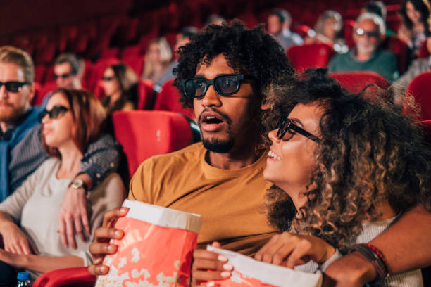 istock Couple hugging and eating popcorn at 3D cinema 1055694120