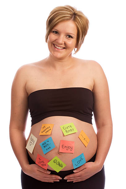 istock Happy pregnant woman with sticky notes on belly 105570253