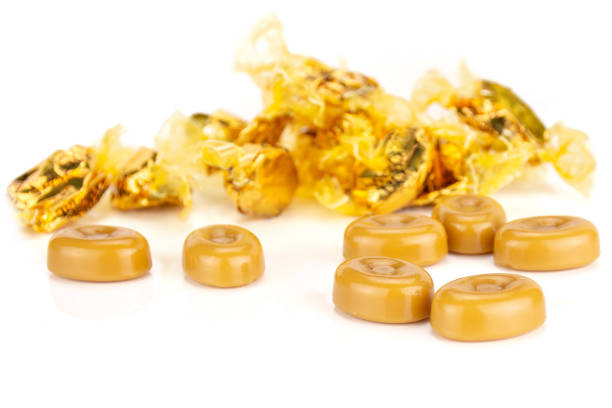 Group of seven whole caramel cream candy butterscotch variety with gliser covered bonbons isolated on white background