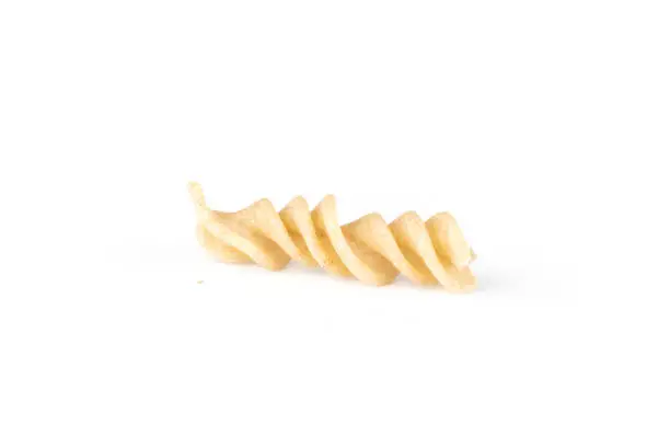 One whole twisted raw pasta fusilli variety isolated on white background