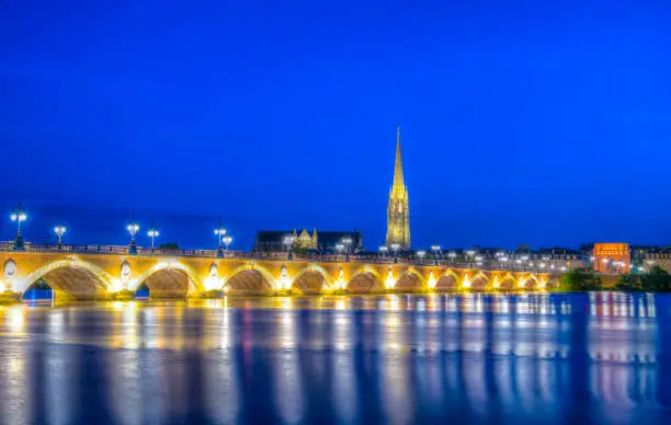 Night view of Pont de Pierre and basilica of Saint Michel in Bordeaux, France