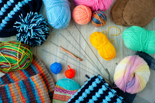Yarn and knitting needles. Colorful yarn and knitting needles on a wooden background. View from above. Knitting as a kind of hobby and needlework. knitting needle photos stock pictures, royalty-free photos & images