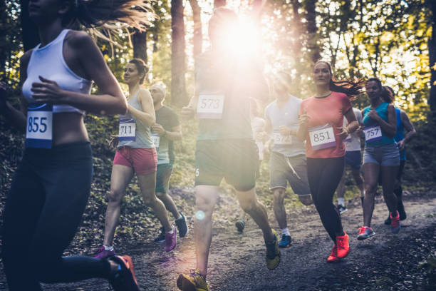 istock Large group of determined athletes running a marathon in nature. 1055862758