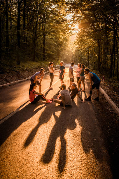 istock Large group of marathon runners communicating on the road at sunset. 1055863342