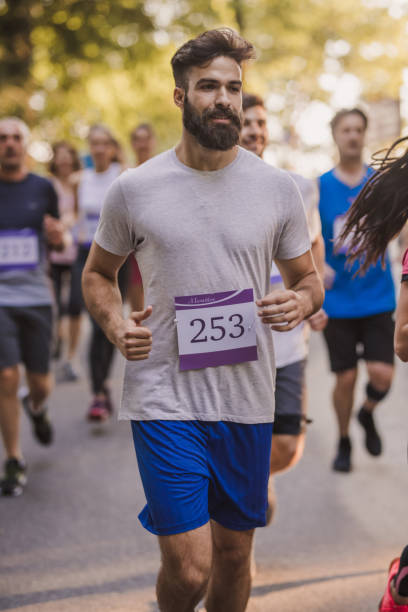 istock Young bearded man running a marathon race in nature. 1055864456