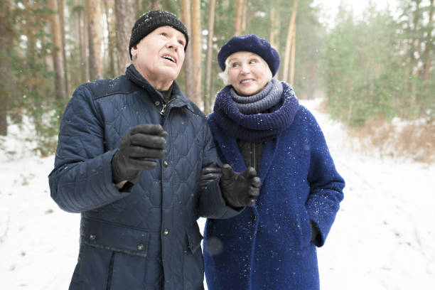 istock Senior Couple Walking in Winter Forest 1055865858