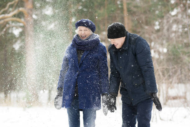 istock Senior Couple Playing with Snow 1055865872