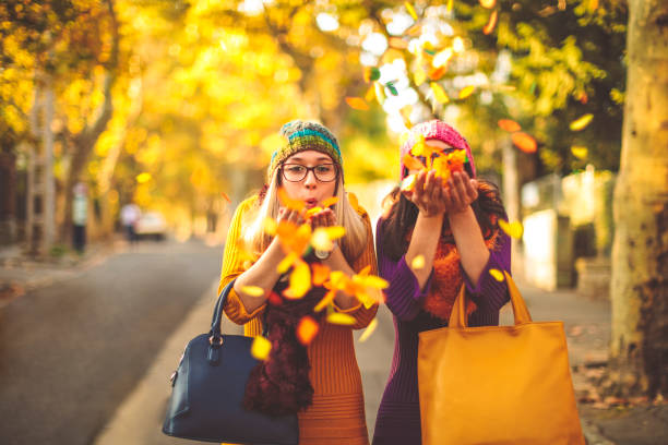 若い女性が市秋の気分で楽しんでいます。 - autumn women smiling leaf ストックフォトと画像