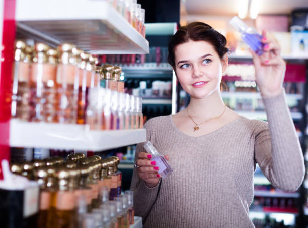 istock young woman customer deciding on perfume variants in cosmetics shop 1055866924