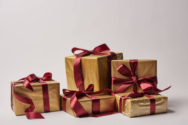 istock Christmas gift boxes with burgundy ribbons isolated on white 1055868422