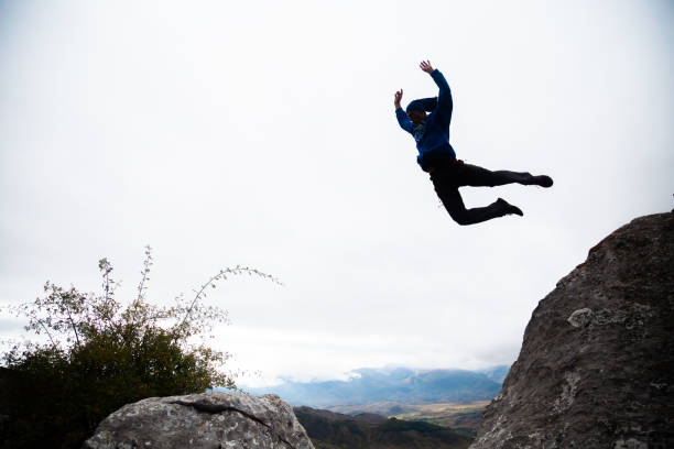 istock Sportive man jumping from rock to rock doing parkour 1055870720
