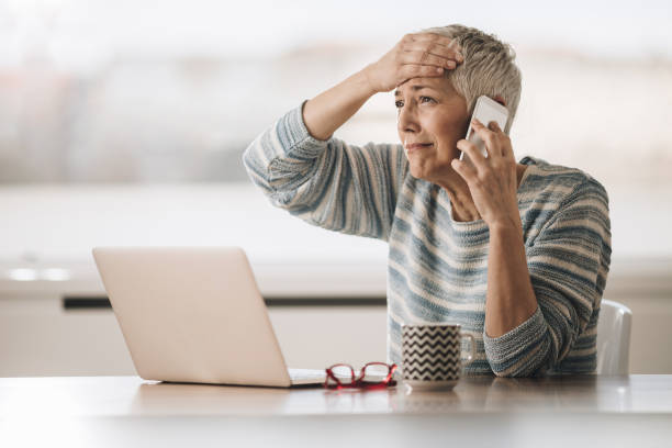 Sad senior woman having problems while talking on cell phone.