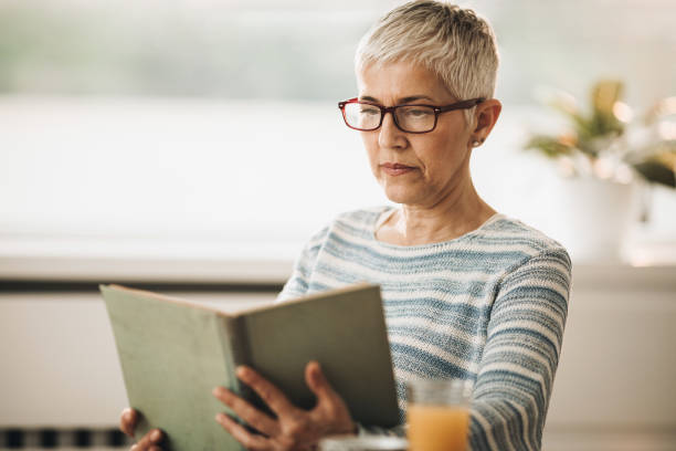istock Senior woman reading a book at home. 1055872172