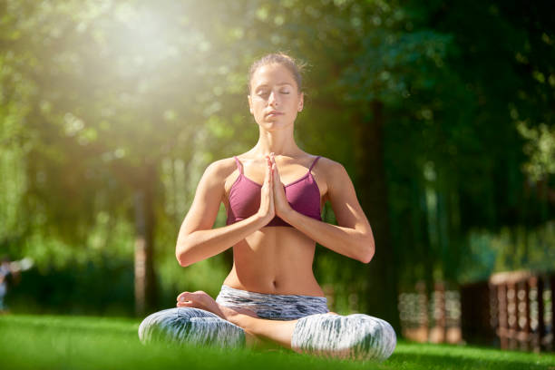 istock Young woman practicing yoga outdoor 1055872234