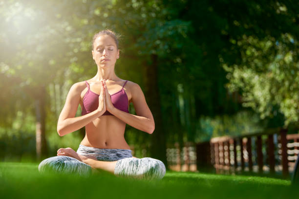 istock Young woman practicing yoga outdoor 1055872266