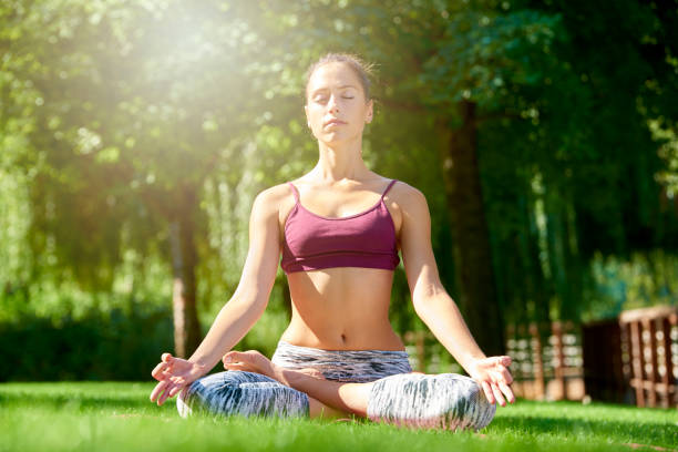 istock Young woman practicing yoga outdoor 1055872296