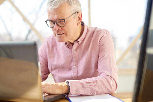 istock Senior buisnessman with laptop 1055872344
