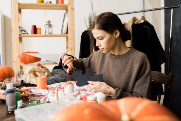 istock Serious craftswoman making Halloween decoration 1055874384